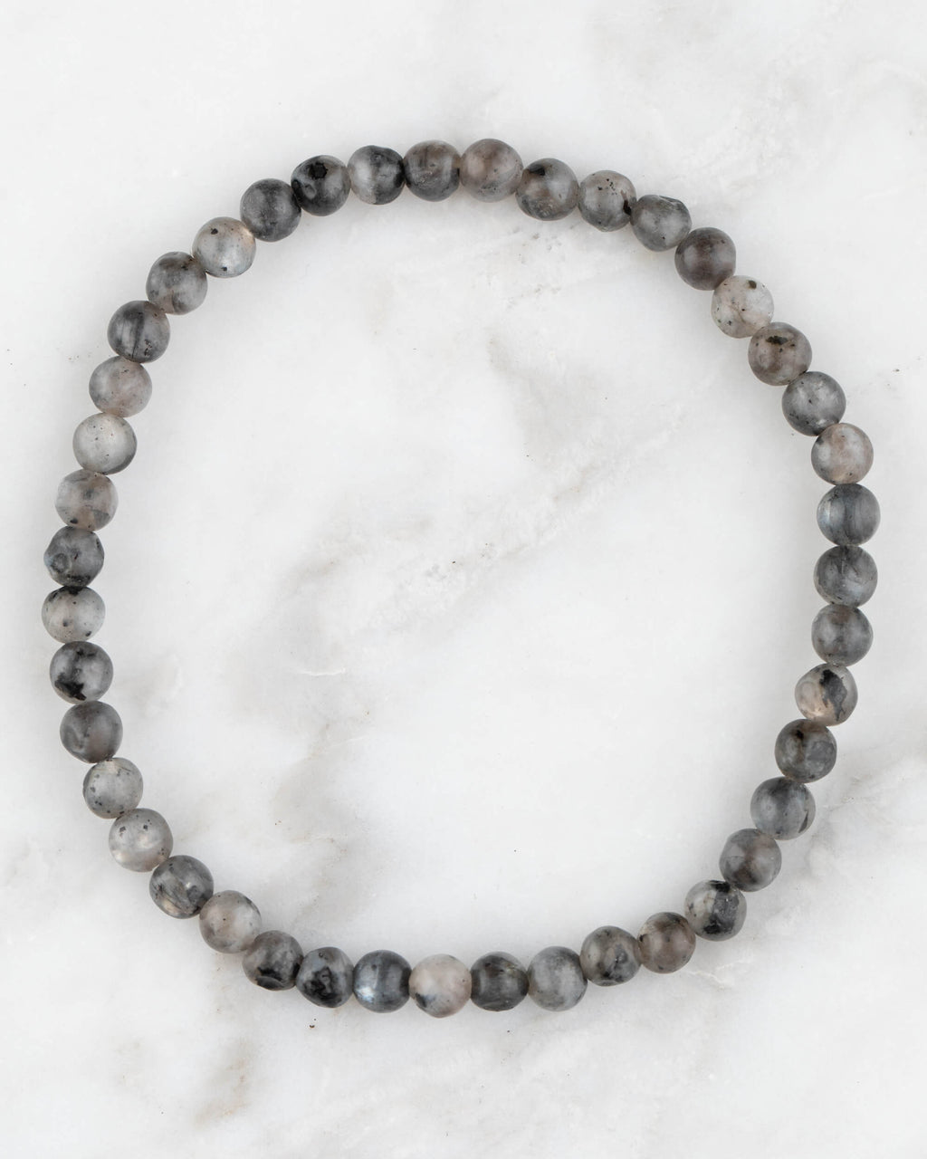 Pulsera de Larvikita de 4 mm, pieza completa en círculo sobre superficie de mármol