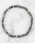 Pulsera de Larvikita de 4 mm, pieza completa en círculo sobre superficie de mármol