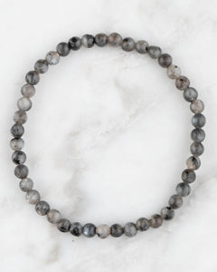 Pulsera de Larvikita de 4 mm, pieza completa en círculo sobre superficie de mármol