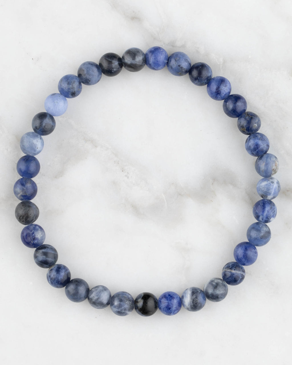 Pulsera de Sodalita de 6 mm, pieza completa en círculo sobre superficie de mármol