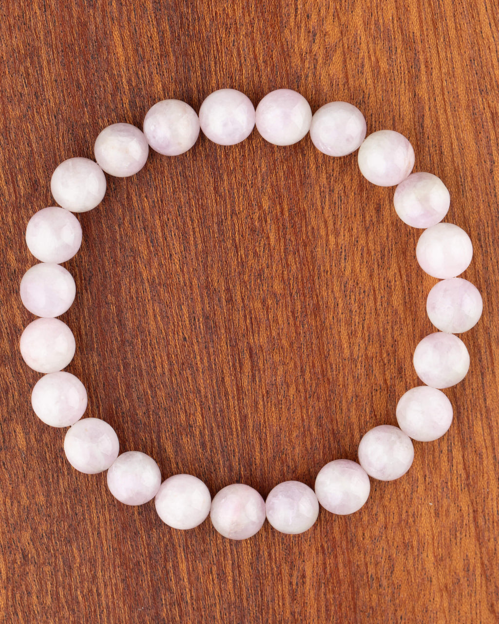 Pulsera de Kunzita de 8 mm, pieza completa sobre madera oscura