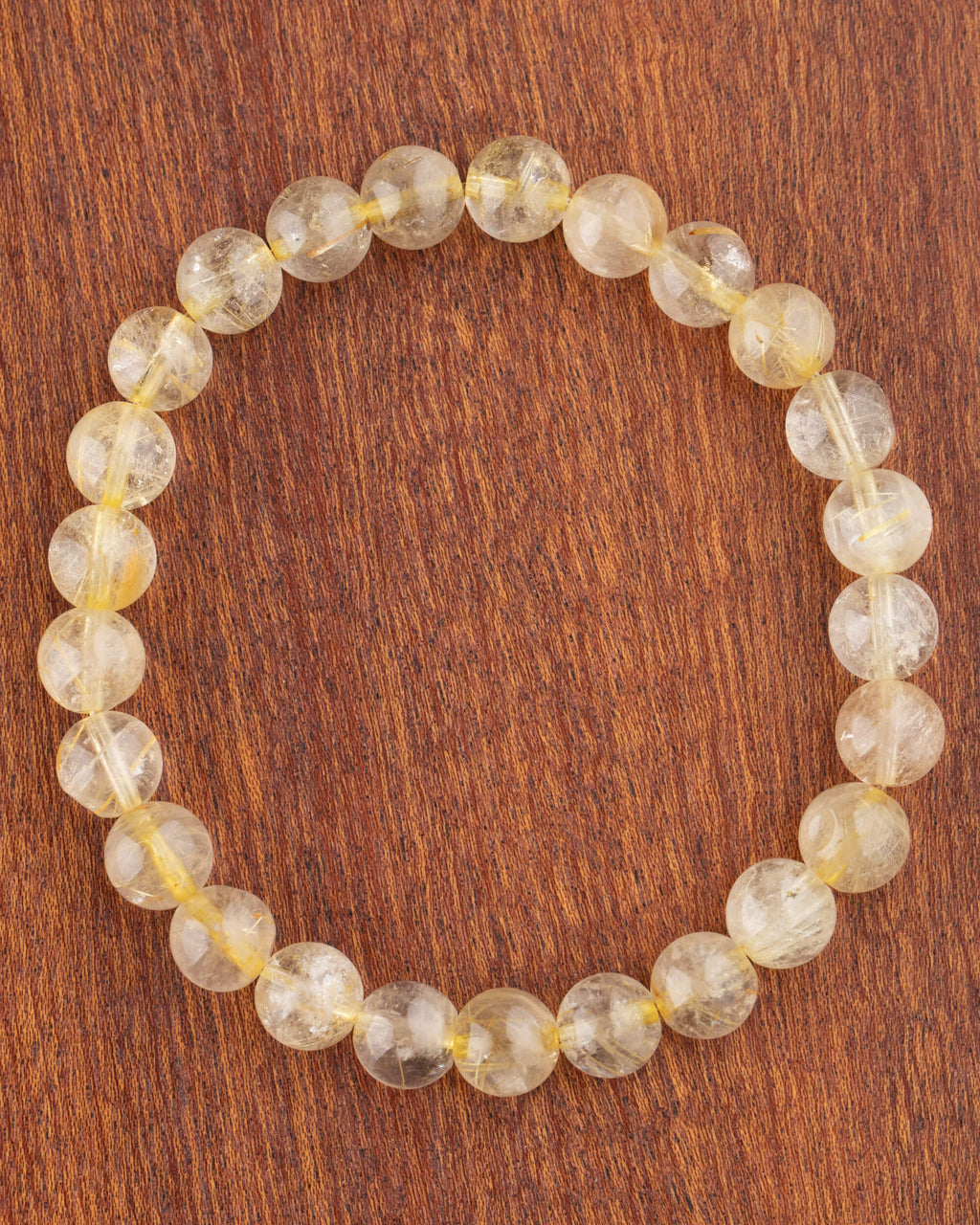 Pulsera de Cuarzo Rutilado de 8 mm, pieza completa en círculo sobre madera
