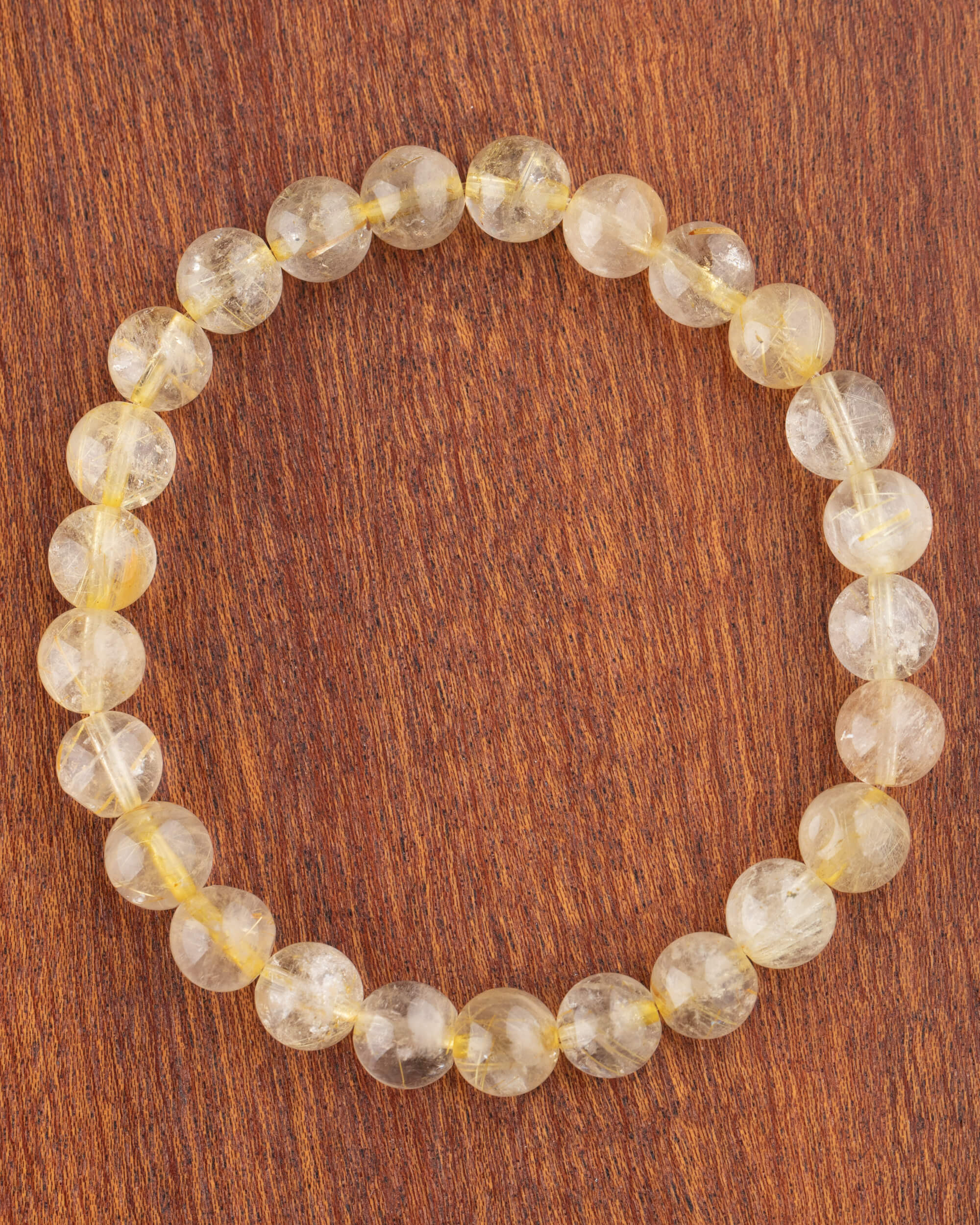 Pulsera de Cuarzo Rutilado de 8 mm, pieza completa en círculo sobre madera