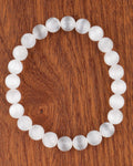 Pulsera de Selenita de 8 mm, pieza completa en círculo sobre superficie de madera