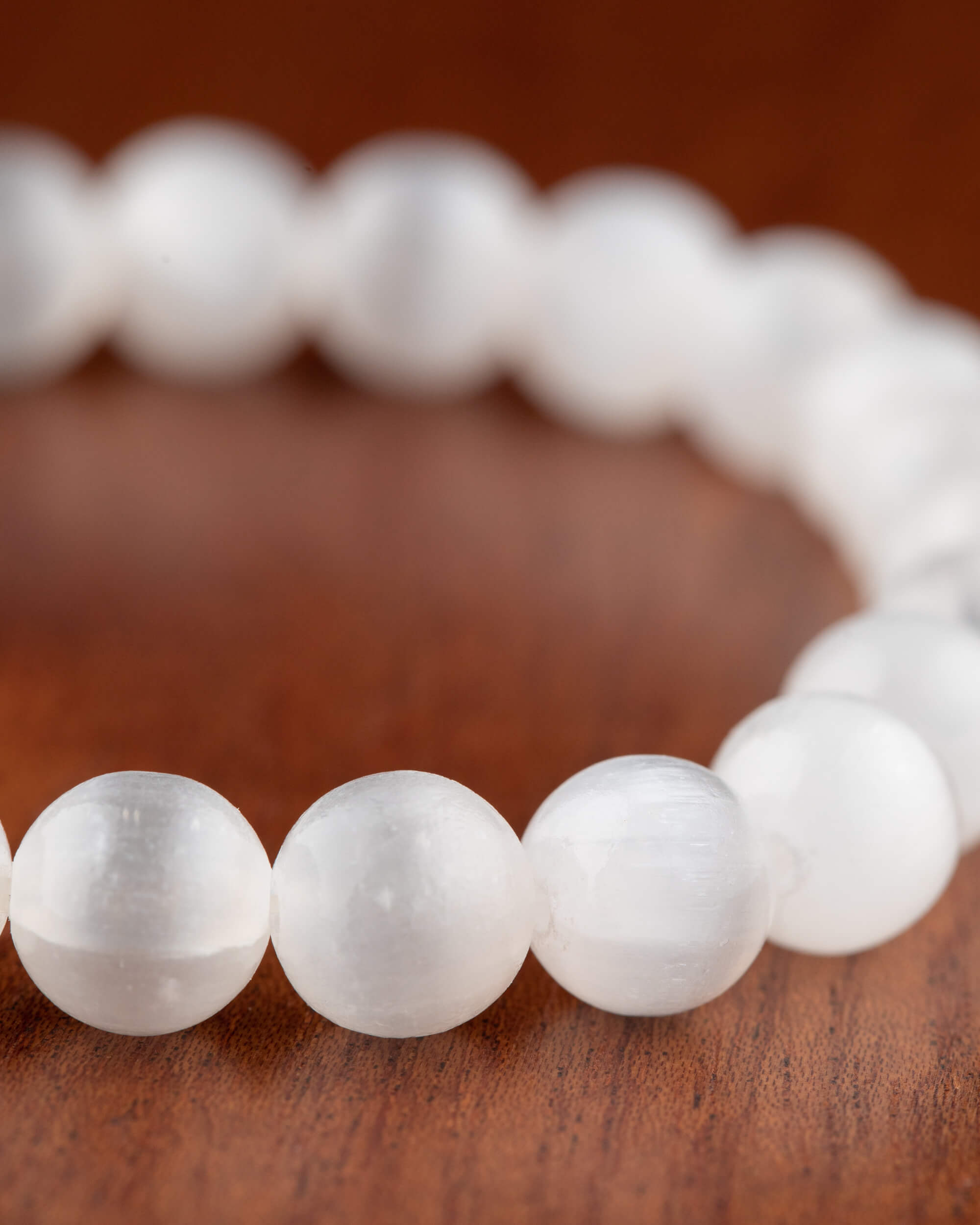 Pulsera de Selenita, vista en perspectiva sobre superficie de madera
