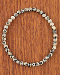 Pulsera de Jaspe Dálmata de 4 mm, pieza completa en círculo sobre madera
