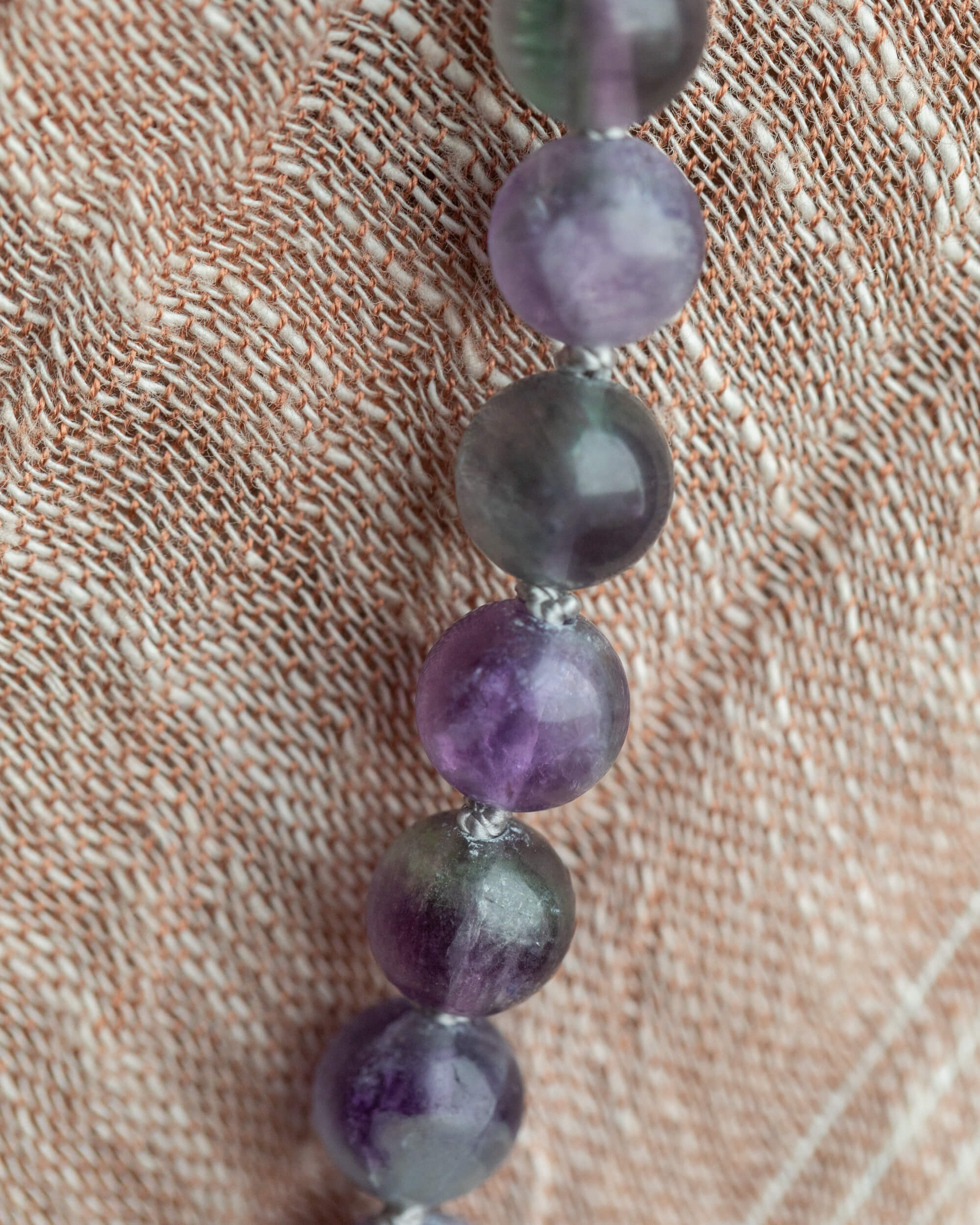 Detalle macro de las cuentas de Fluorita en tonos morado y gris