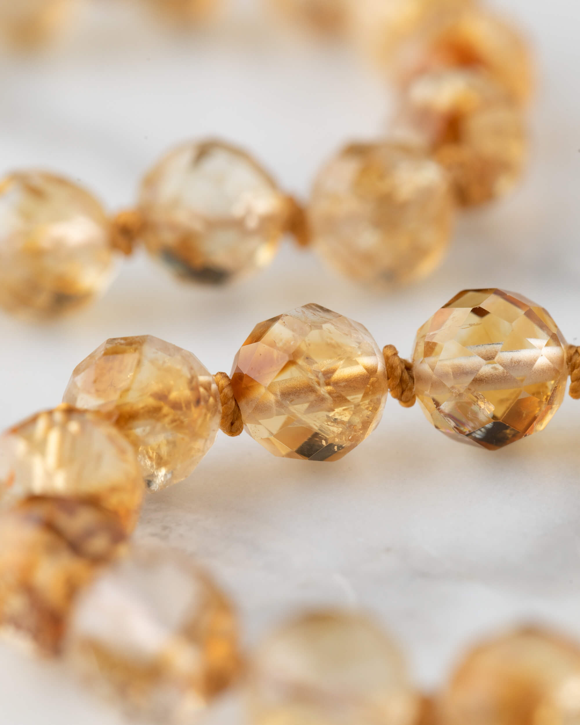 Cuentas facetadas de Citrino en primer plano mostrando el brillo dorado de la piedra