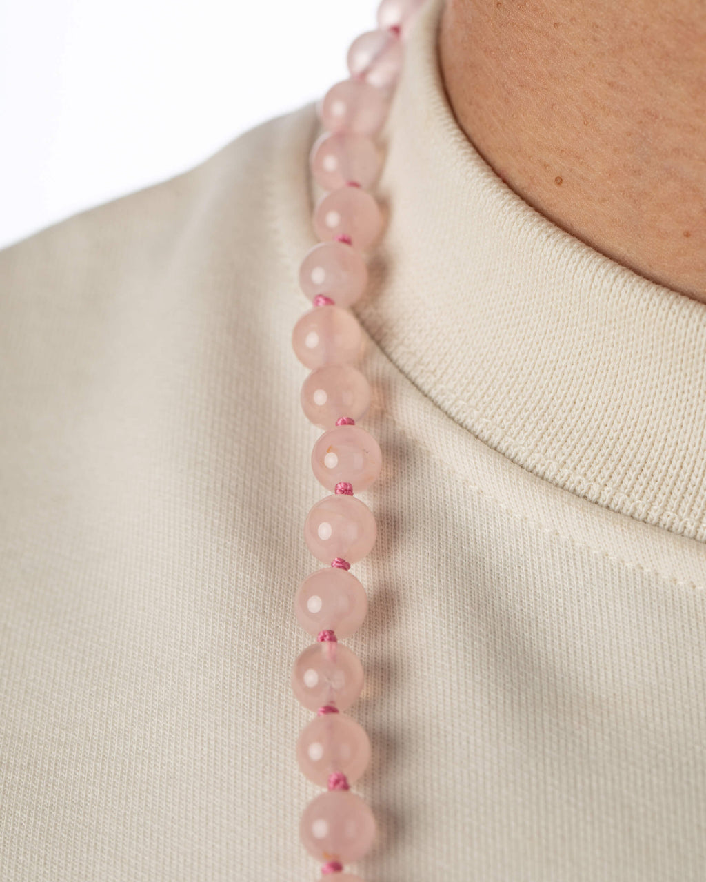 Codificador Doble de Cuarzo Rosa puesto, detalle de las cuentas sobre el cuello
