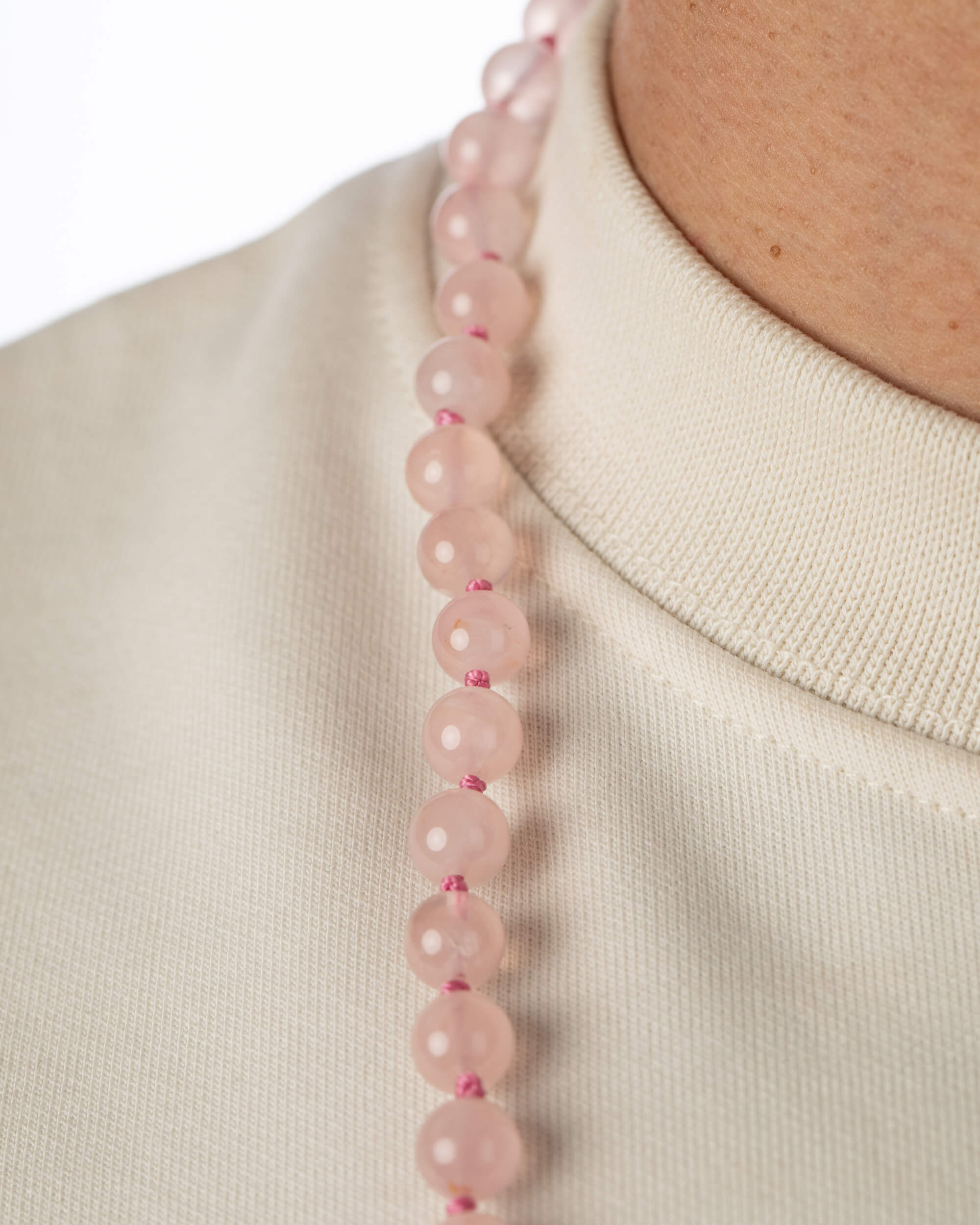 Codificador Doble de Cuarzo Rosa puesto, detalle de las cuentas sobre el cuello