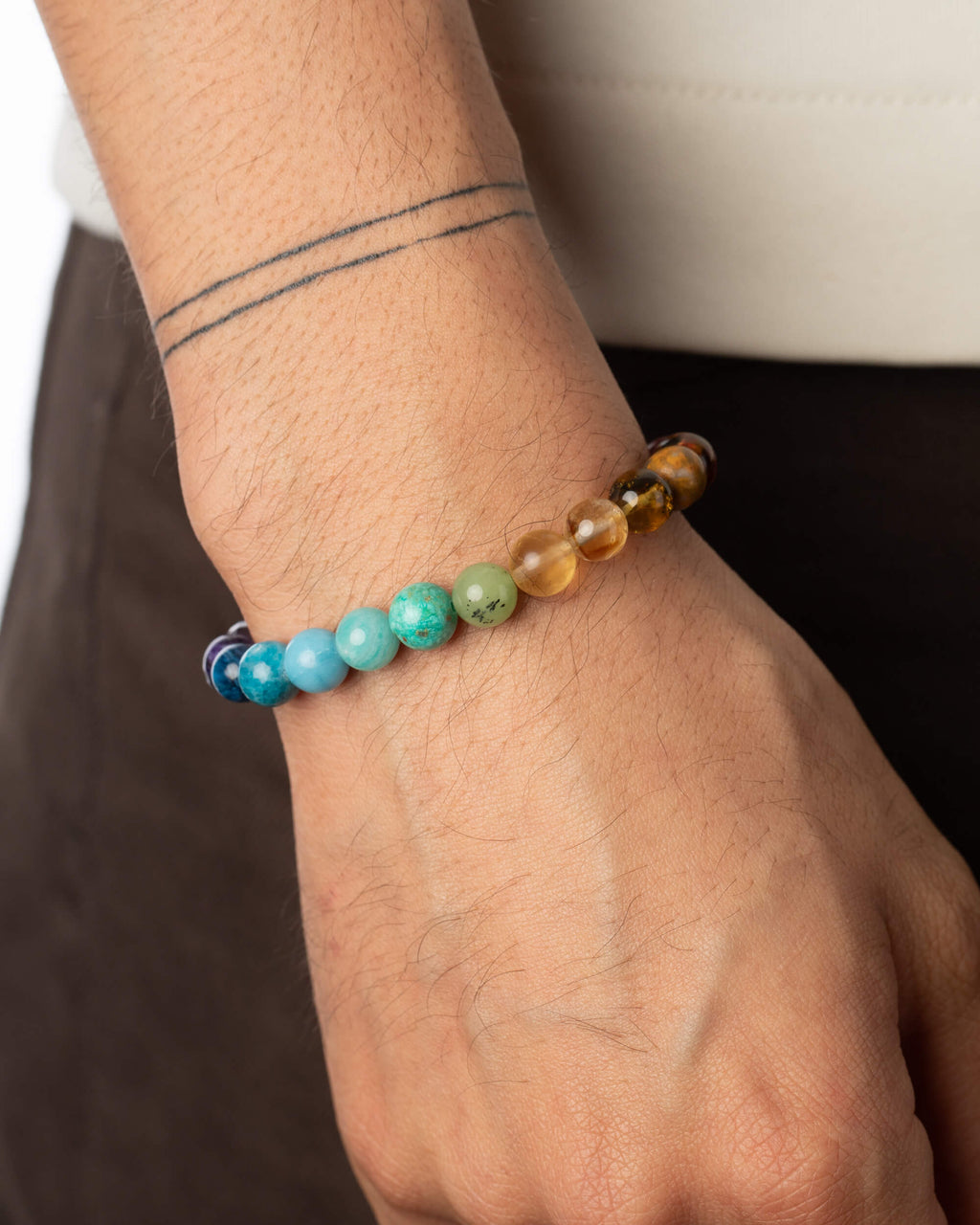 Pulsera 7 Chakras puesta en la muñeca, cuentas multicolor visibles al detalle