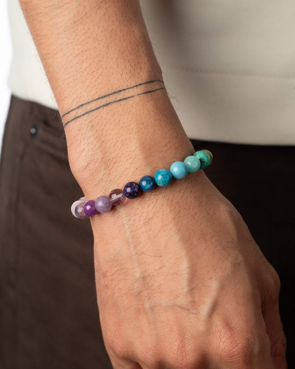 Pulsera 7 Chakras puesta en la muñeca, degradado de violeta a turquesa