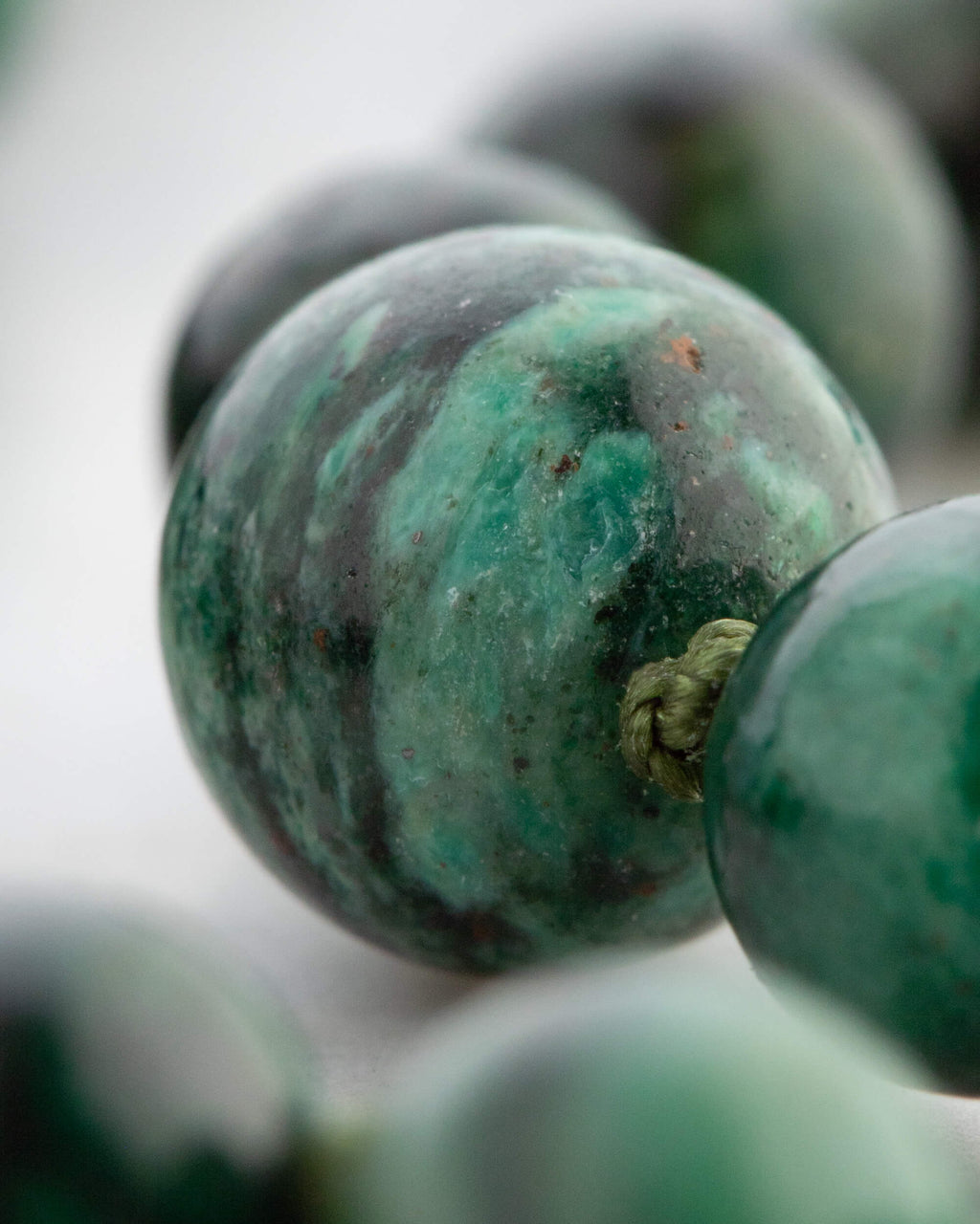 Detalle macro de una cuenta de Esmeralda en Matriz de Biotita con vetas verdes