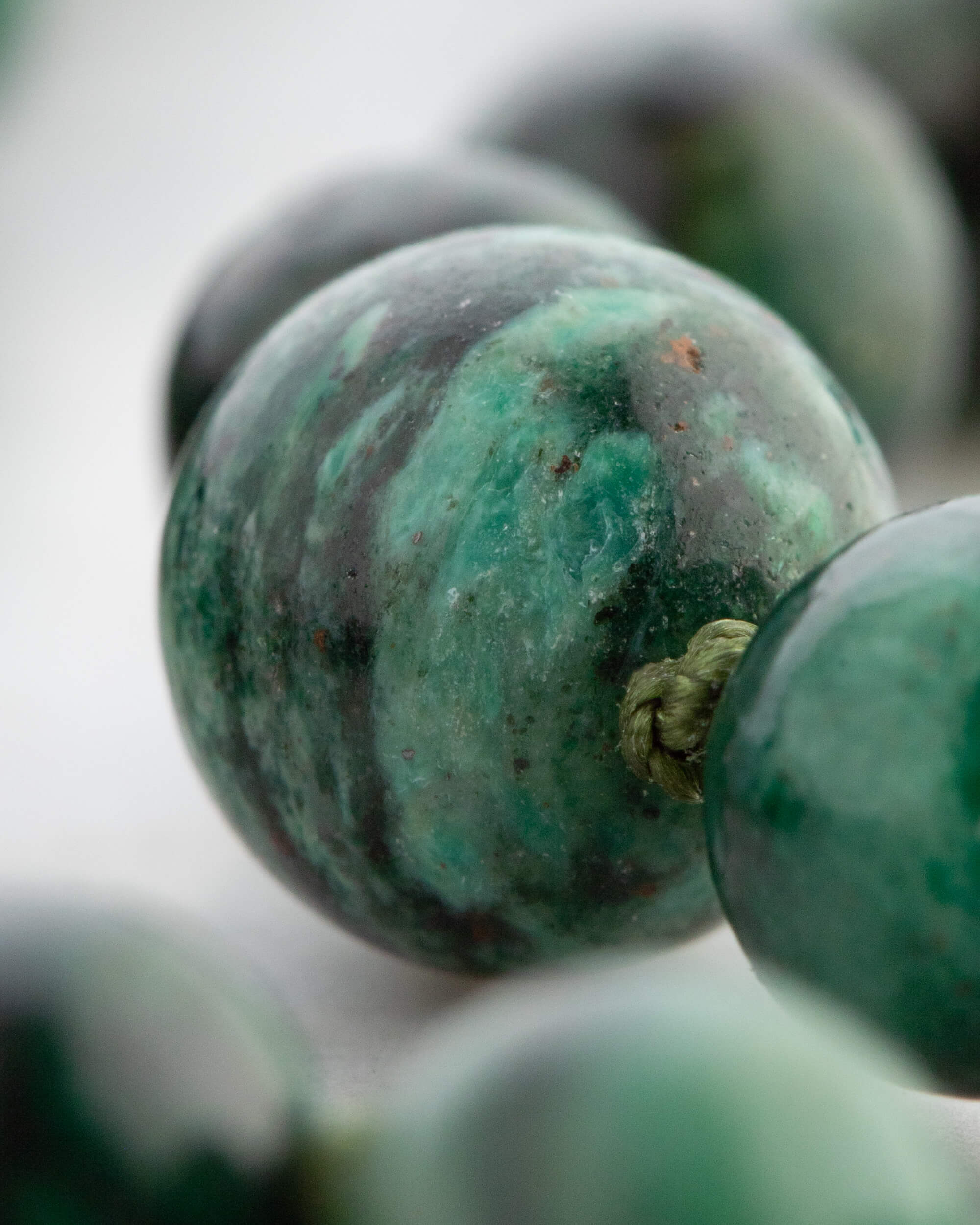 Detalle macro de una cuenta de Esmeralda en Matriz de Biotita con vetas verdes