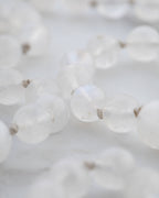 Detalle macro de las cuentas de Piedra Luna con destellos de luz