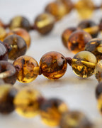 Detalle macro de las cuentas de Ámbar y Granate Estrella con nudo central visible