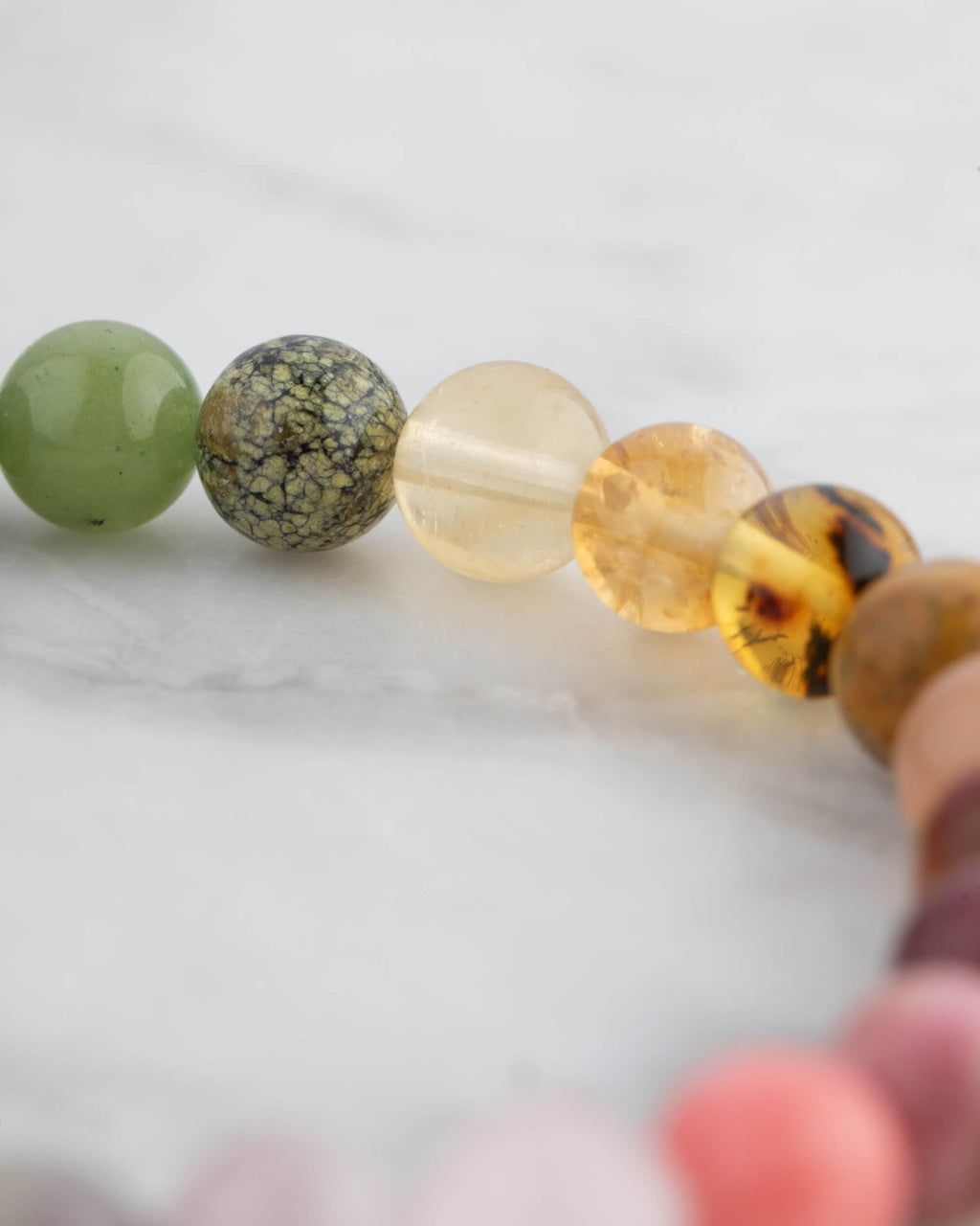 Detalle macro de las cuentas verdes y doradas de la Pulsera 7 Chakras