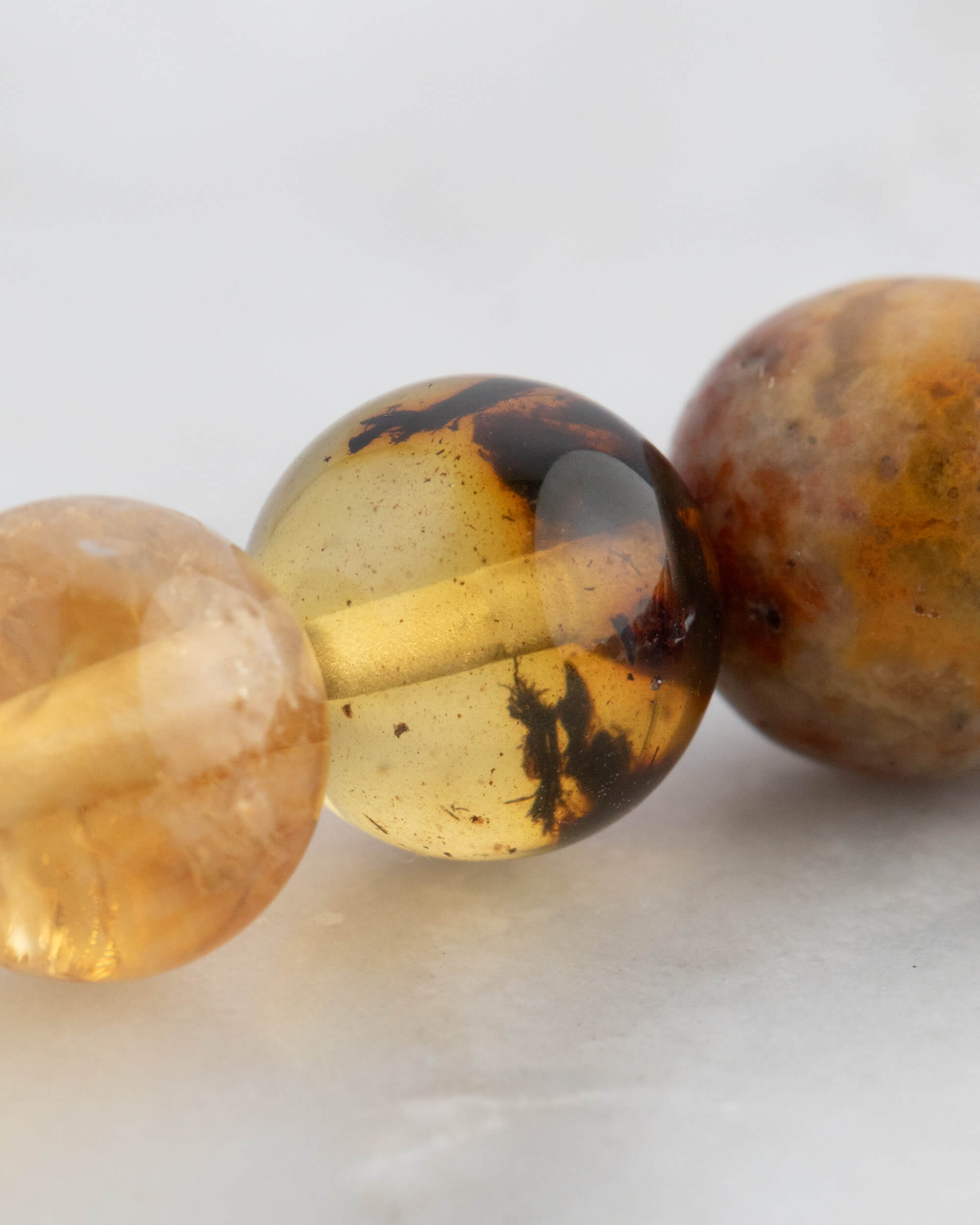 Detalle macro de las cuentas doradas y ambar de la Pulsera 7 Chakras
