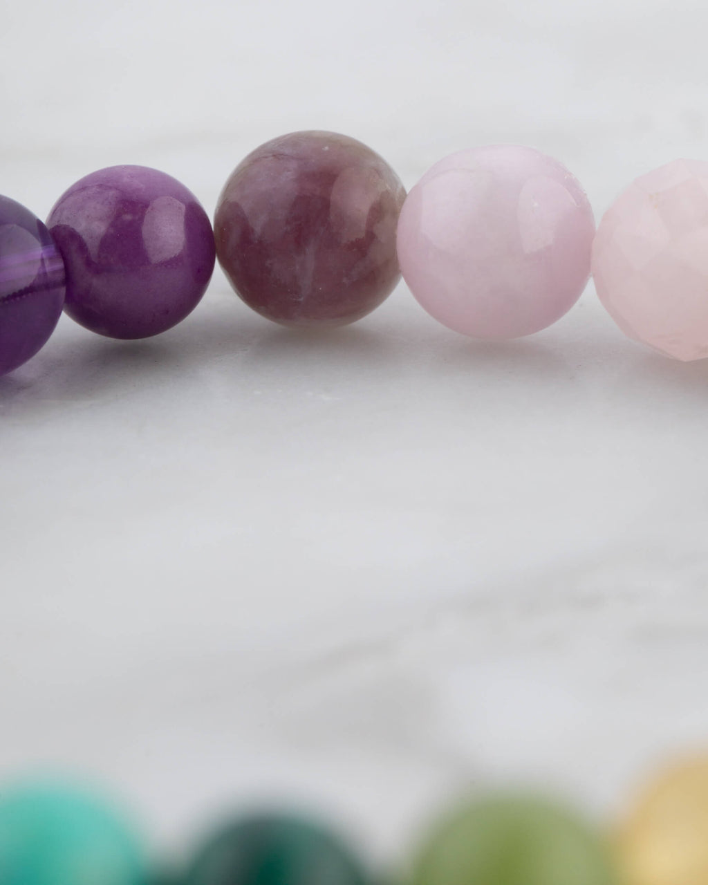 Detalle macro de las cuentas lila, violeta y rosa de la Pulsera 7 Chakras