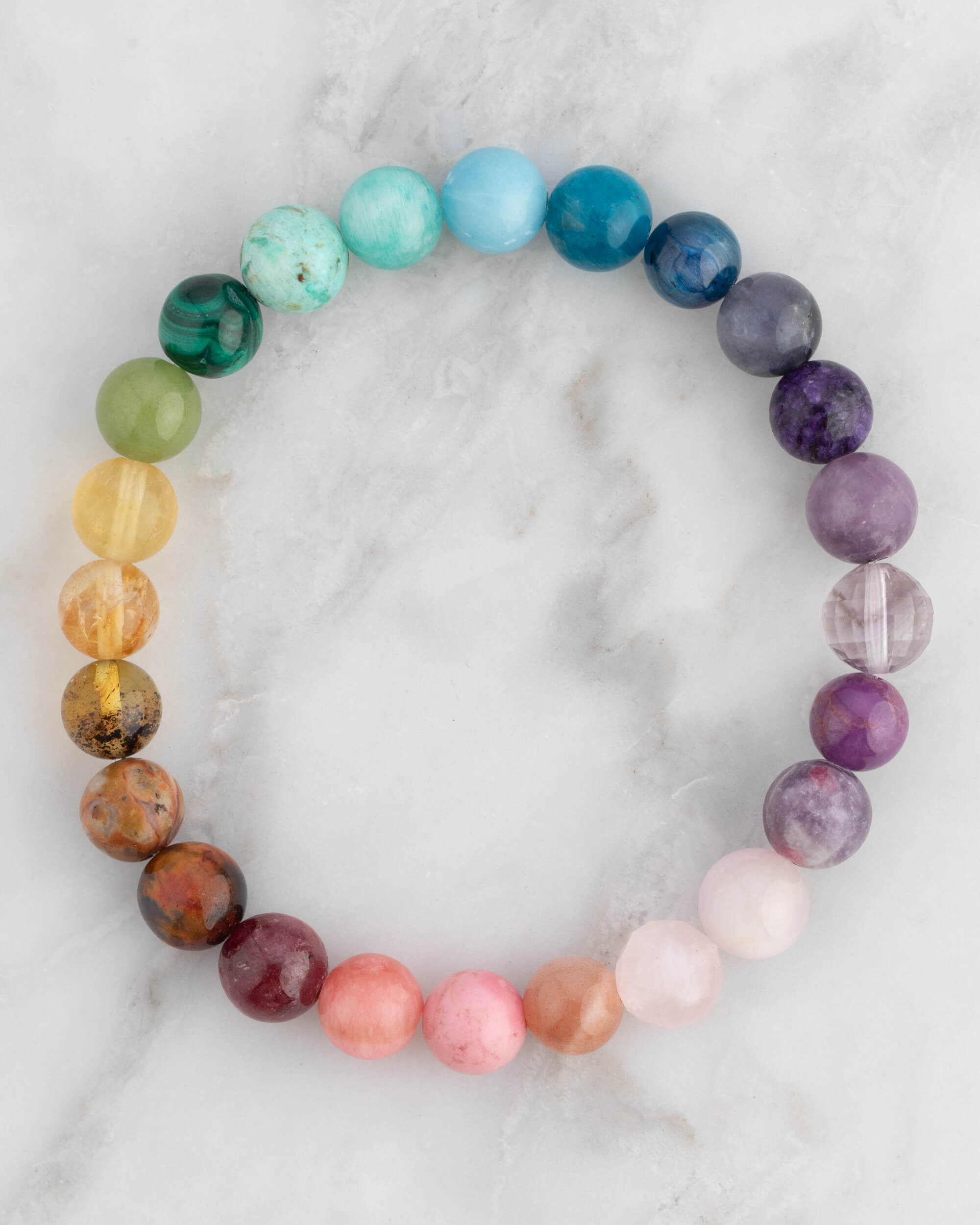 Pulsera 7 Chakras en círculo, pieza completa con cuentas multicolor sobre mármol