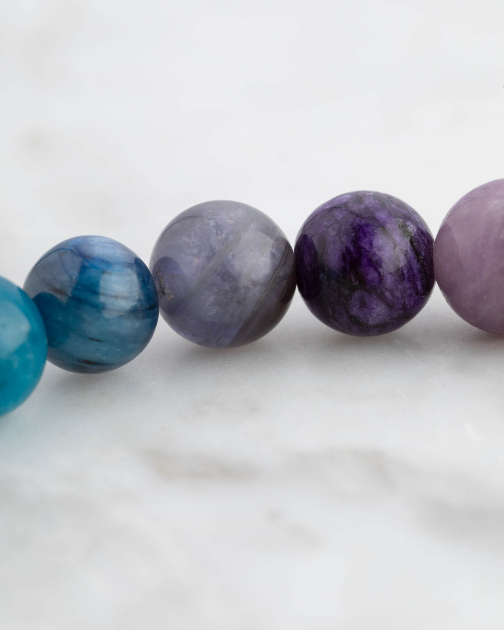 Detalle macro de cuentas azules, gris y moradas de la Pulsera 7 Chakras