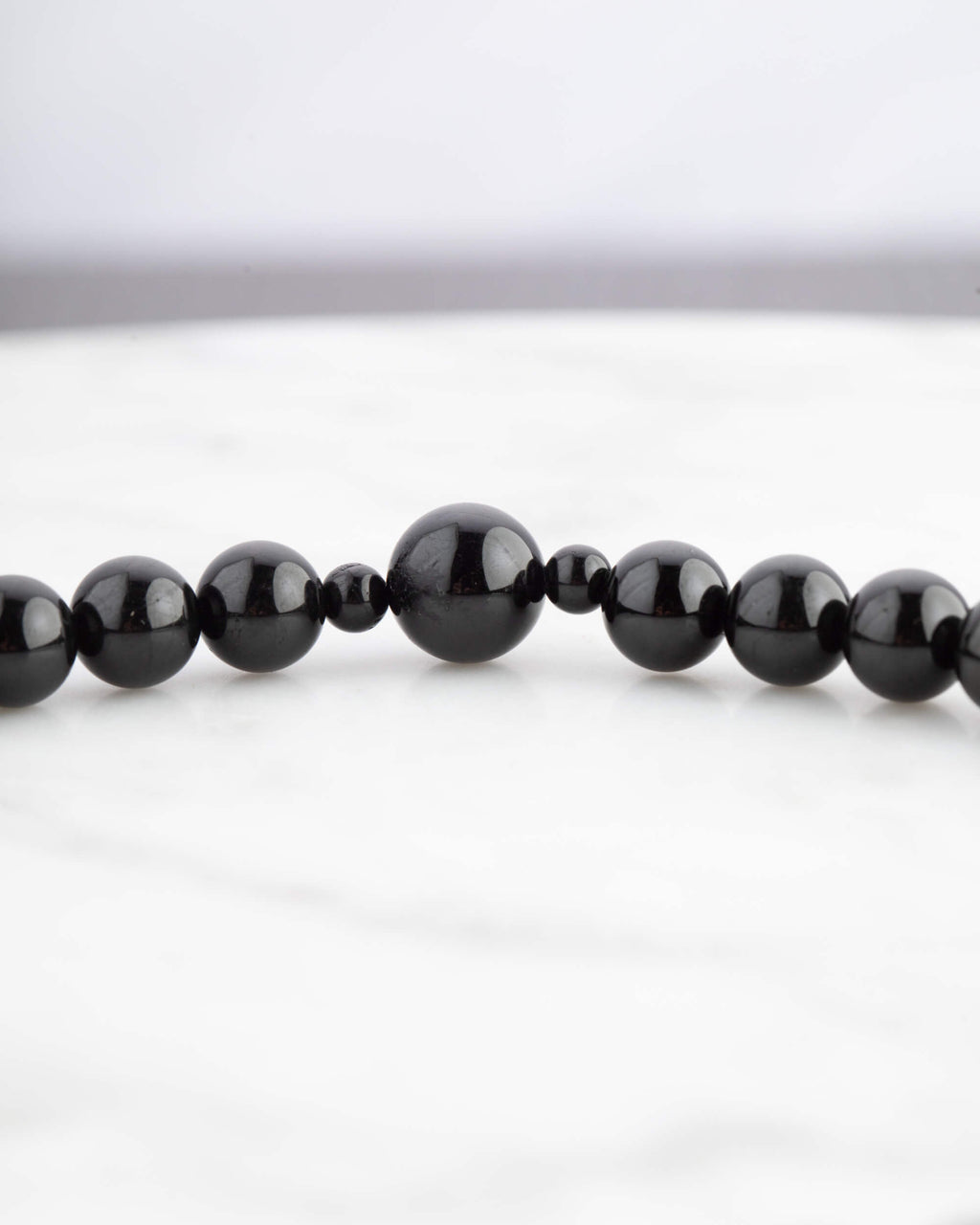 Detalle macro de cuentas de Turmalina Negra brillantes con talla escalonada del Codificador