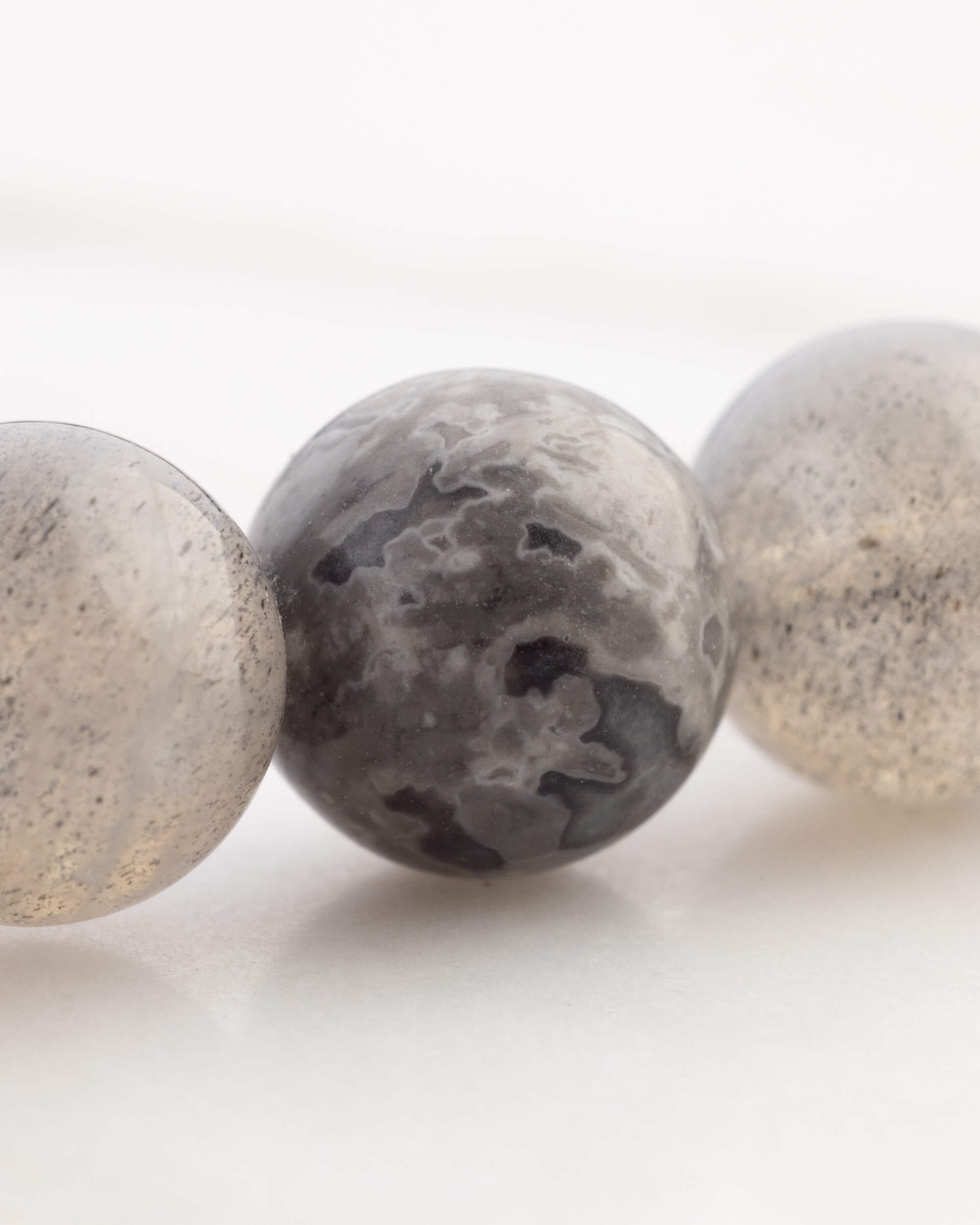 Detalle macro de una cuenta gris moteada con manchas negras del Codificador Dualidad