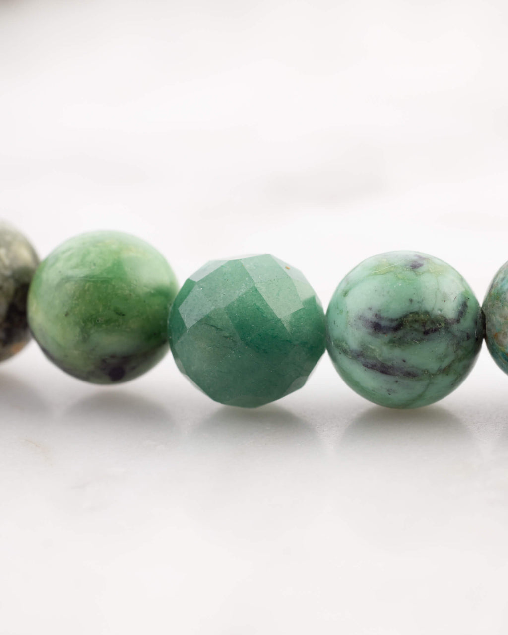 Detalle macro de cuentas de Turquesa Africana, Serpentina y Ágata Arbol