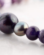 Detalle macro de perlas barrocas negras y Amatista del Codificador Universo