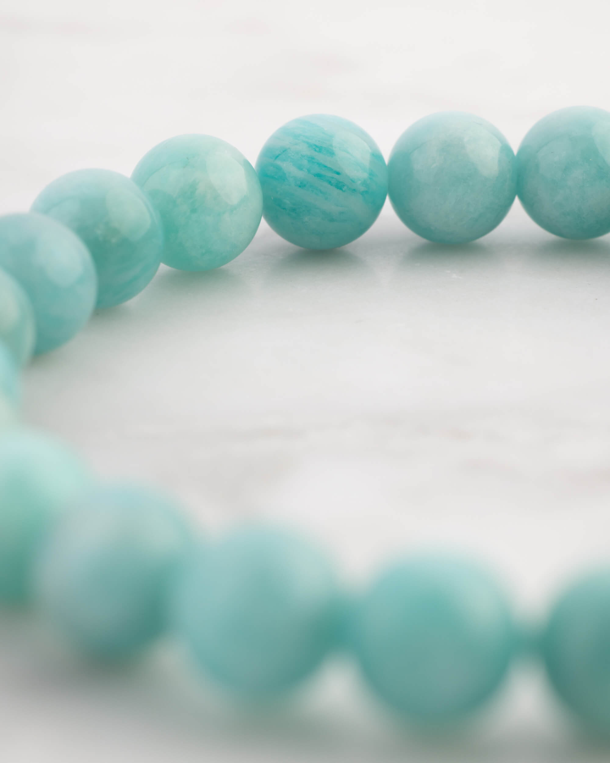 Pulsera de Amazonita Aqua en ángulo cercano sobre superficie clara