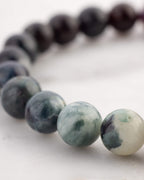 Detalle macro de las cuentas de Turmalina Negra junto al tramo verde de la pulsera