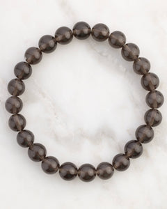 Pulsera de Saffordita de 8 mm, pieza completa en círculo sobre superficie de mármol claro