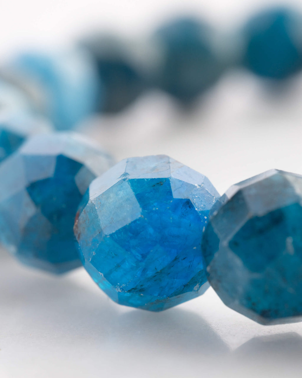 Detalle macro de las cuentas facetadas de Apatita Azul con múltiples caras talladas