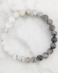 Pulsera de Cuarzo Turmalinado facetada de 8 mm, pieza completa en círculo sobre mármol claro