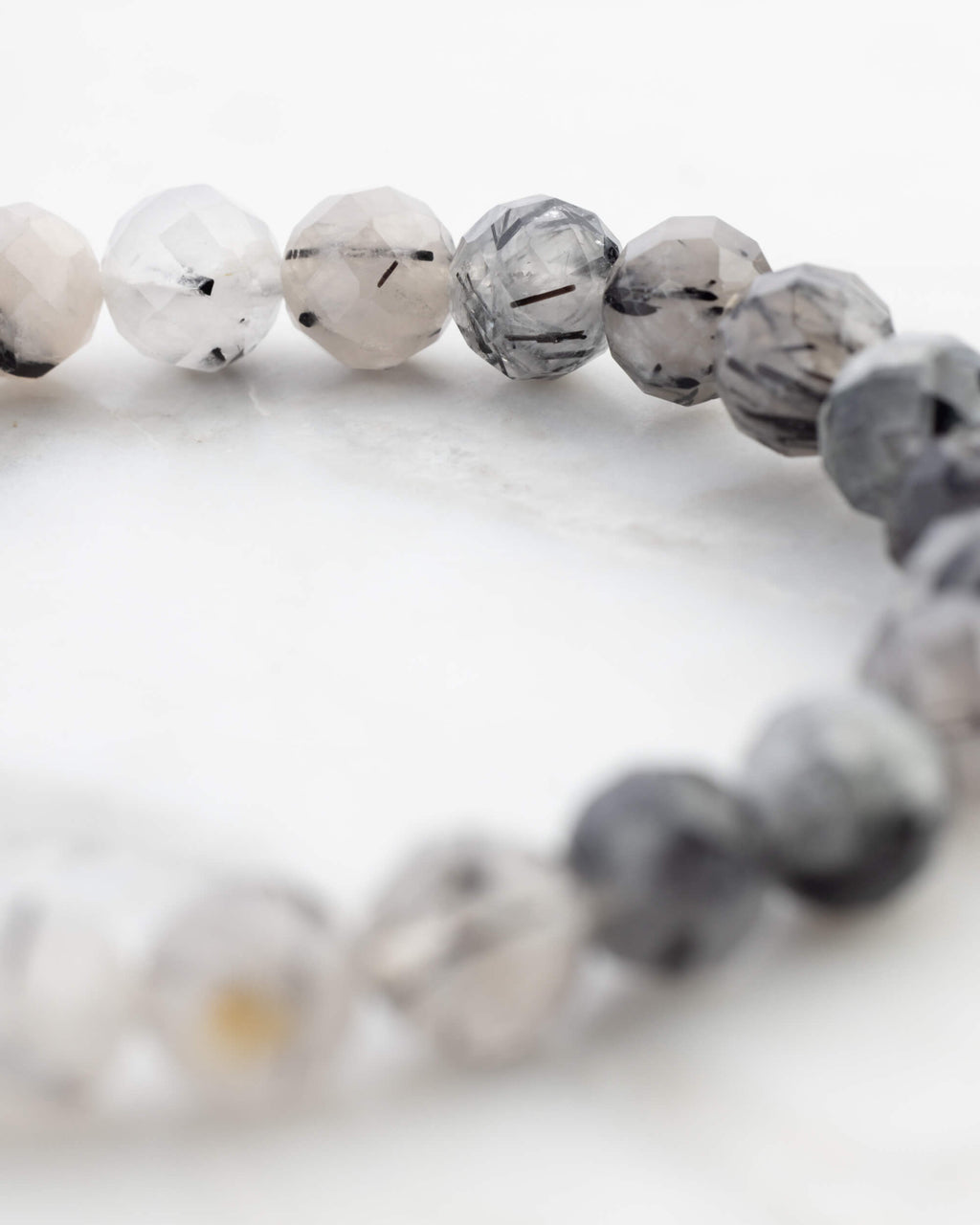 Pulsera de Cuarzo Turmalinado facetada en círculo desde otro angulo, con degradado claro a oscuro