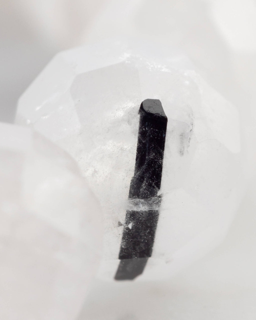 Detalle macro de una inclusión de Turmalina Negra dentro de una cuenta de Cuarzo transparente