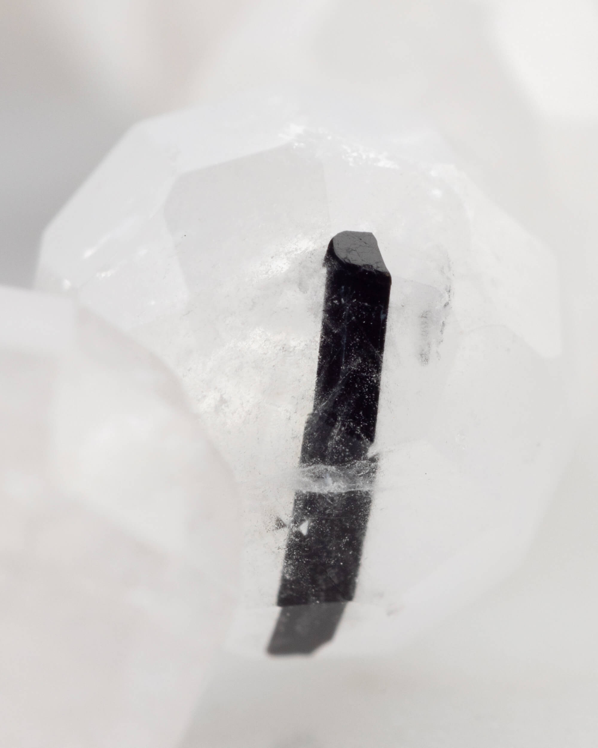 Detalle macro de una inclusión de Turmalina Negra dentro de una cuenta de Cuarzo transparente