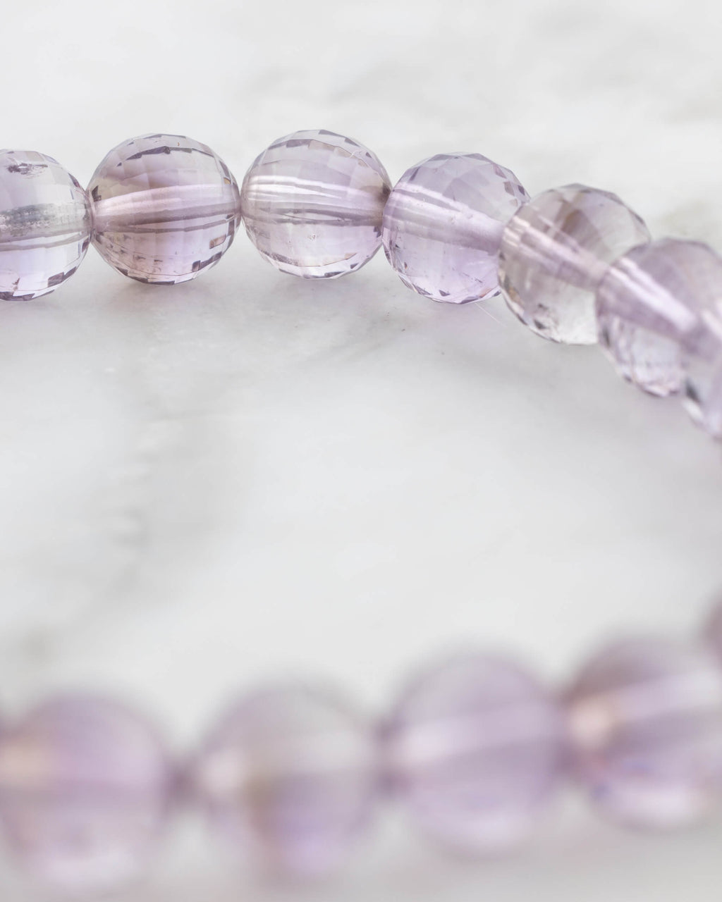 Pulsera de Amatista facetada en ángulo cercano sobre superficie clara