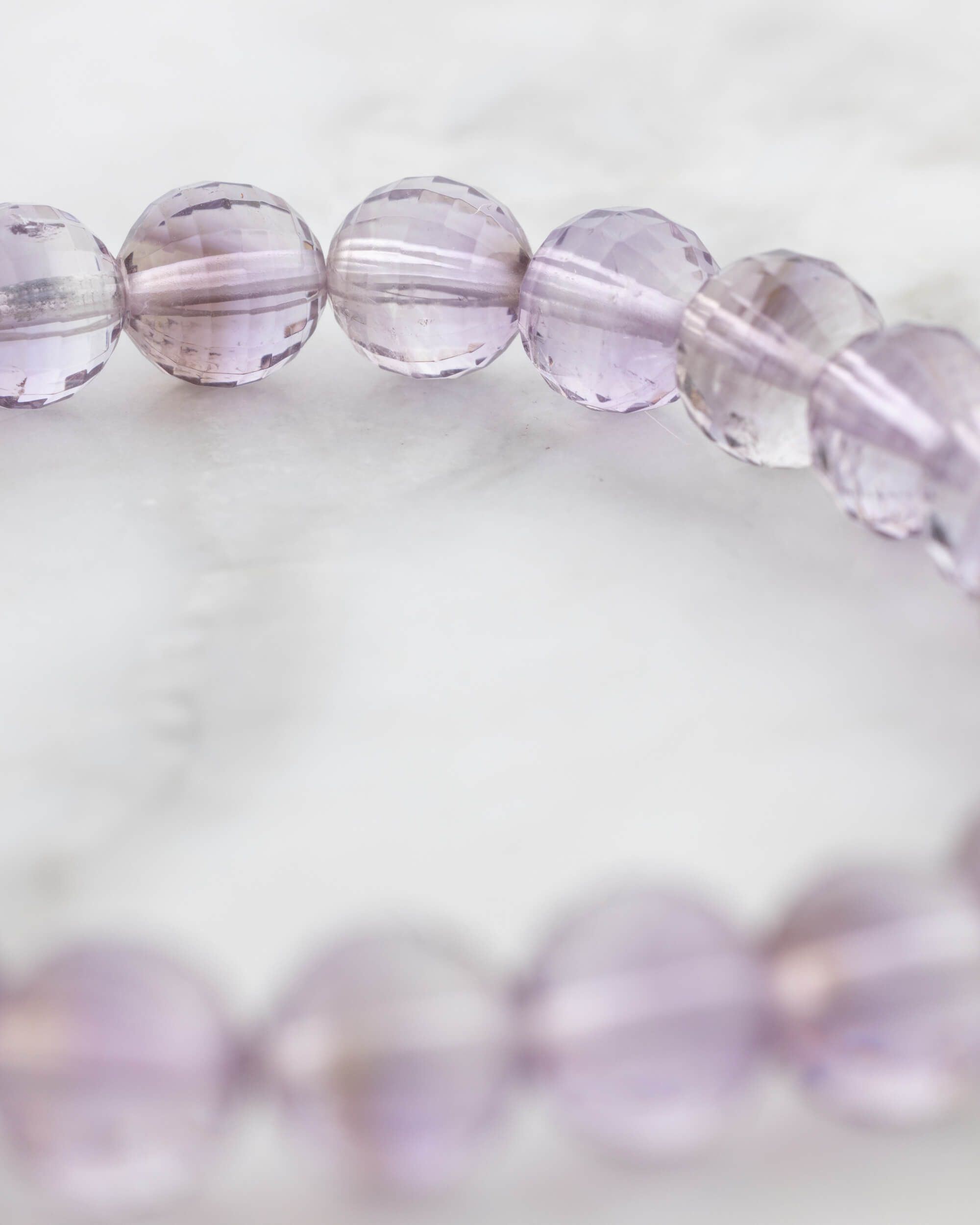 Pulsera de Amatista facetada en ángulo cercano sobre superficie clara
