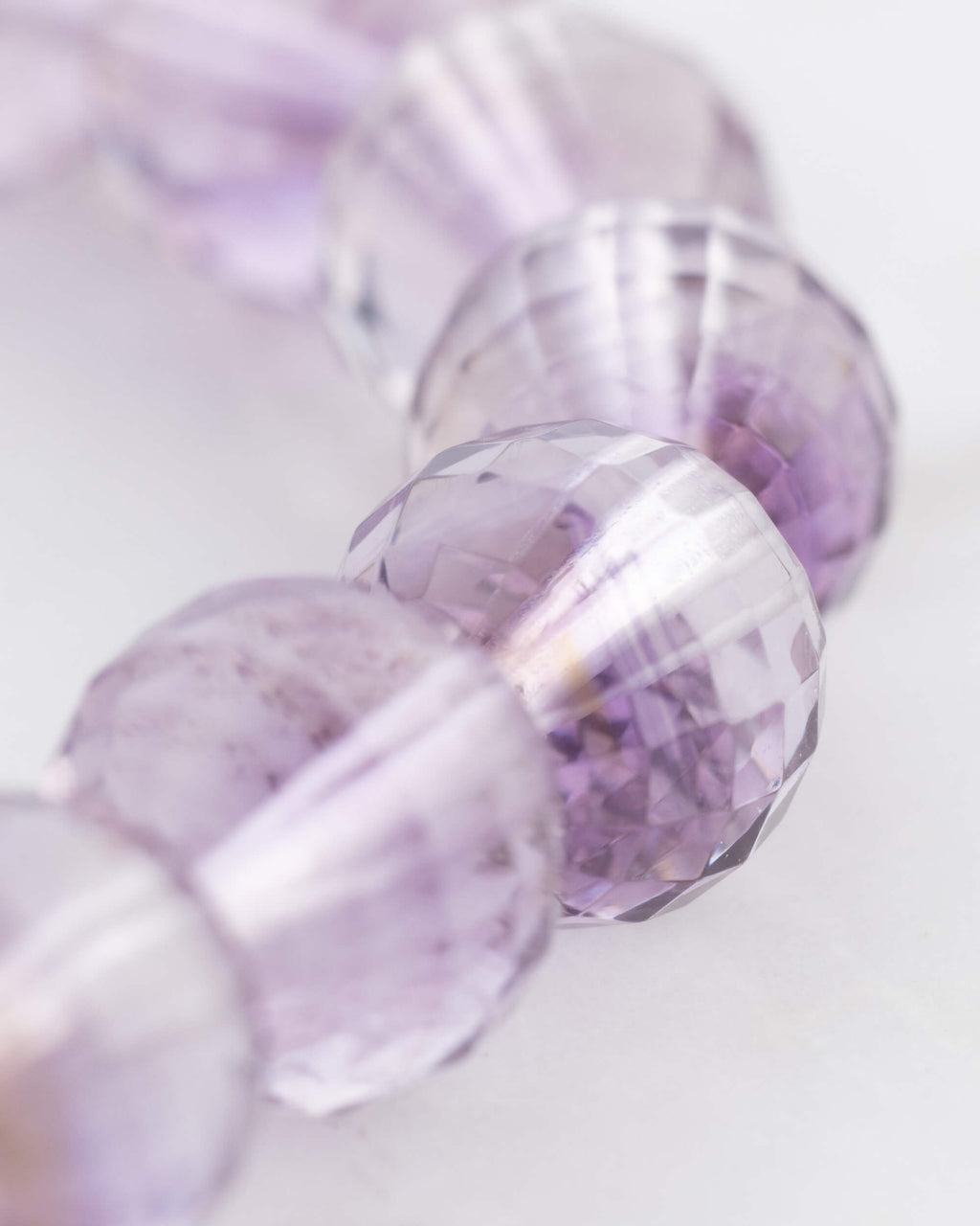 Detalle macro de las cuentas facetadas de Amatista con vetas violeta suaves