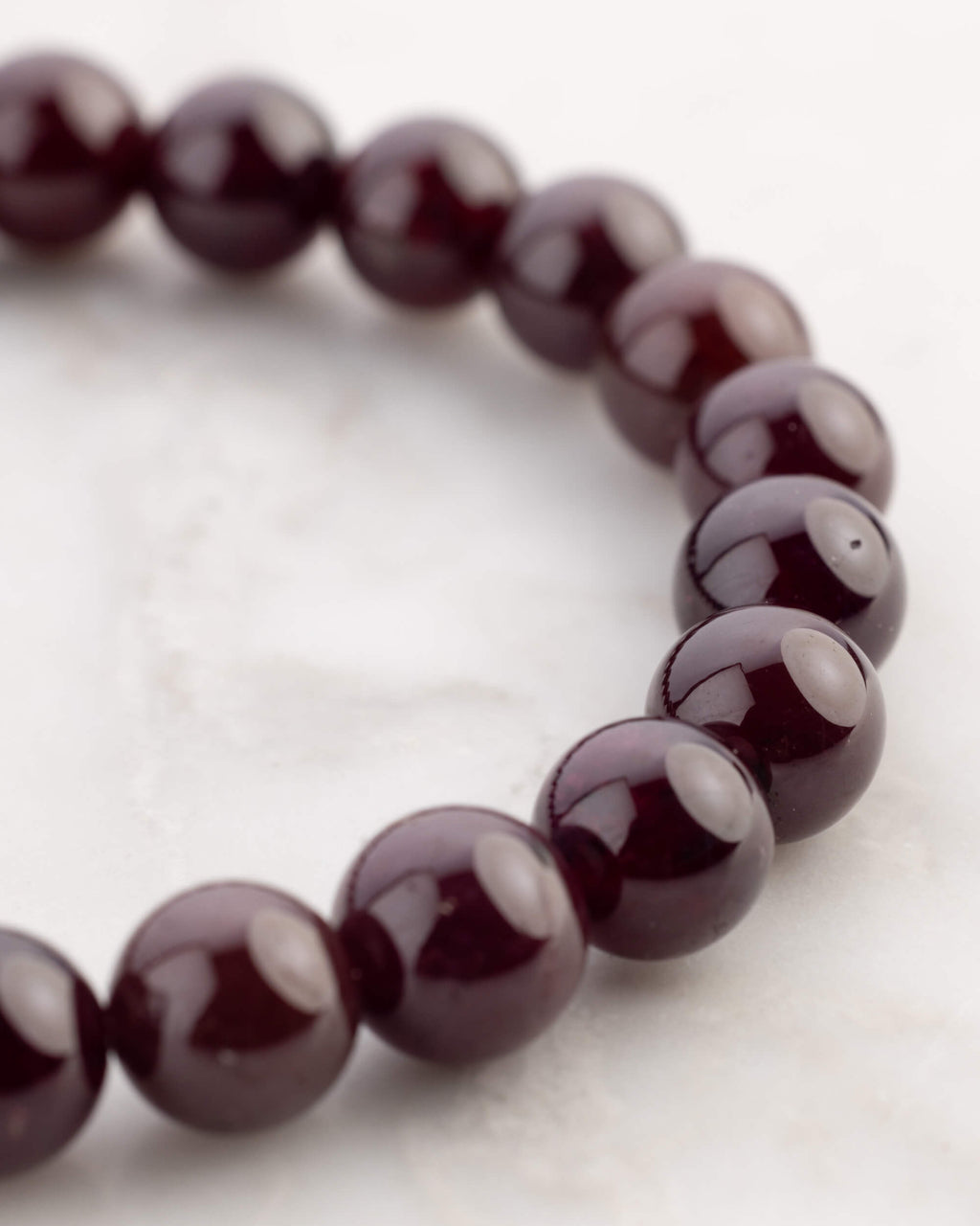 Pulsera de Granate Estrella en círculo desde otro angulo, mostrando el brillo de las cuentas