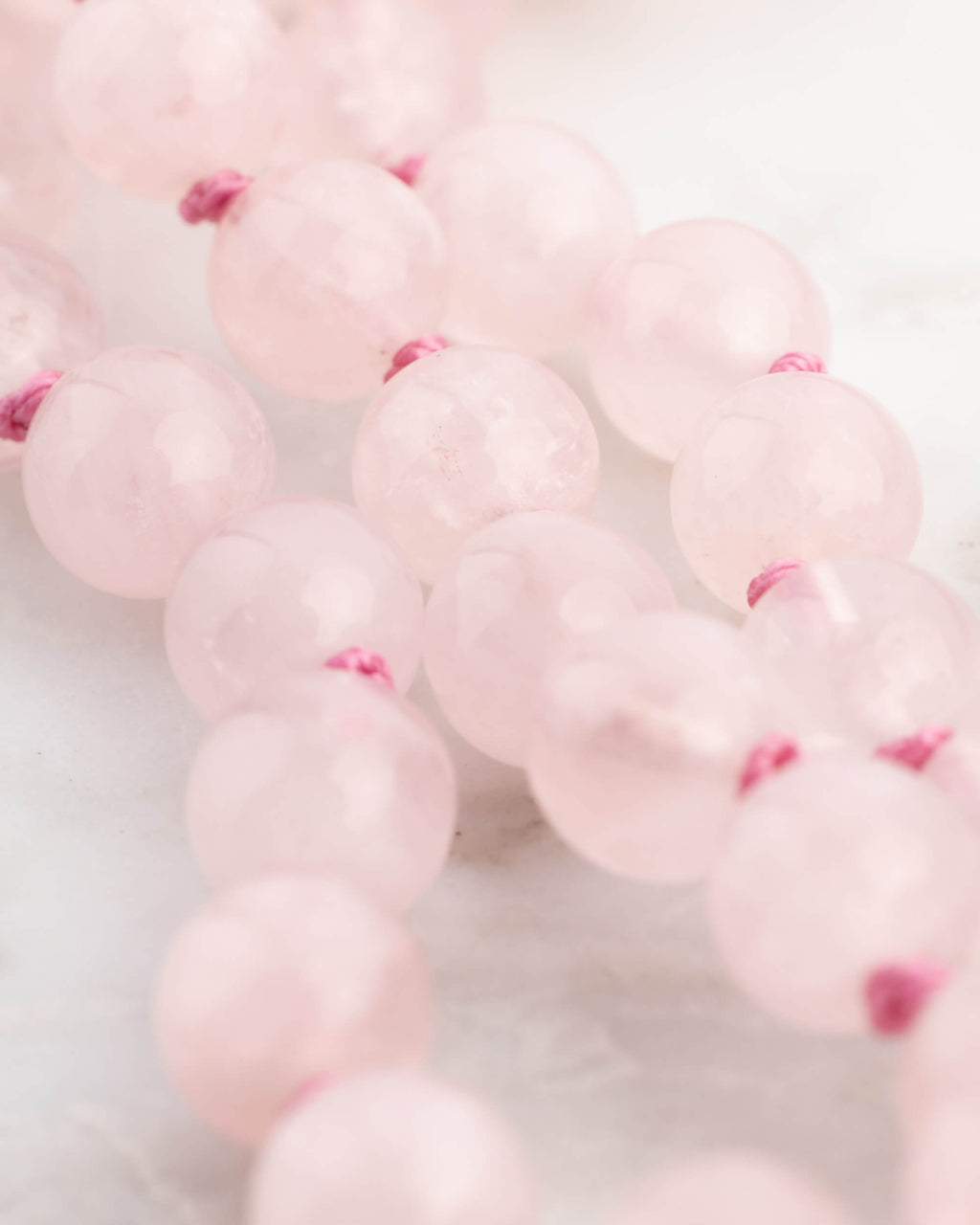 Detalle macro de las cuentas de Cuarzo Rosa con nudos entre cada una
