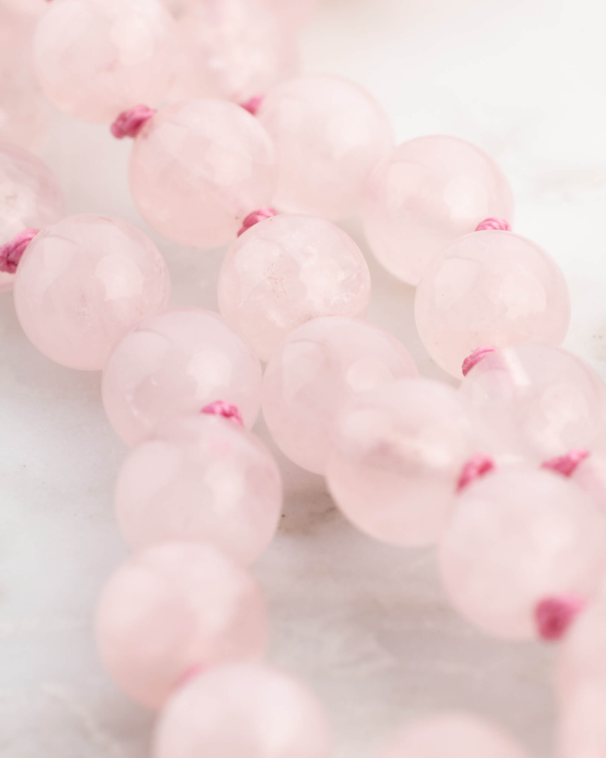Detalle macro de las cuentas de Cuarzo Rosa con nudos entre cada una