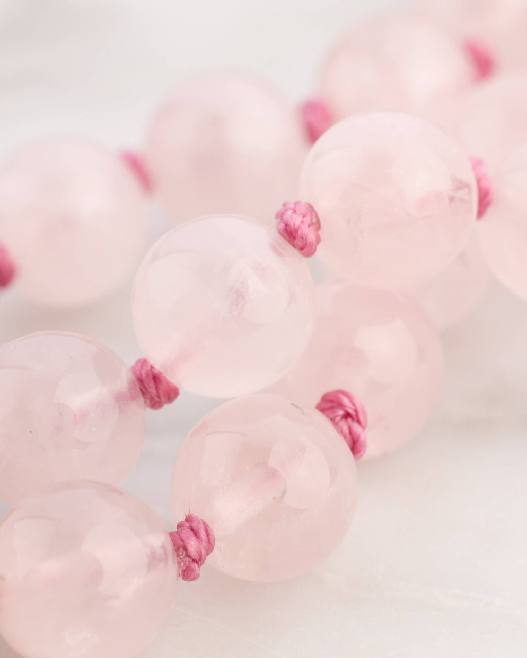 Detalle macro de las cuentas de Cuarzo Rosa con nudos entre cada una