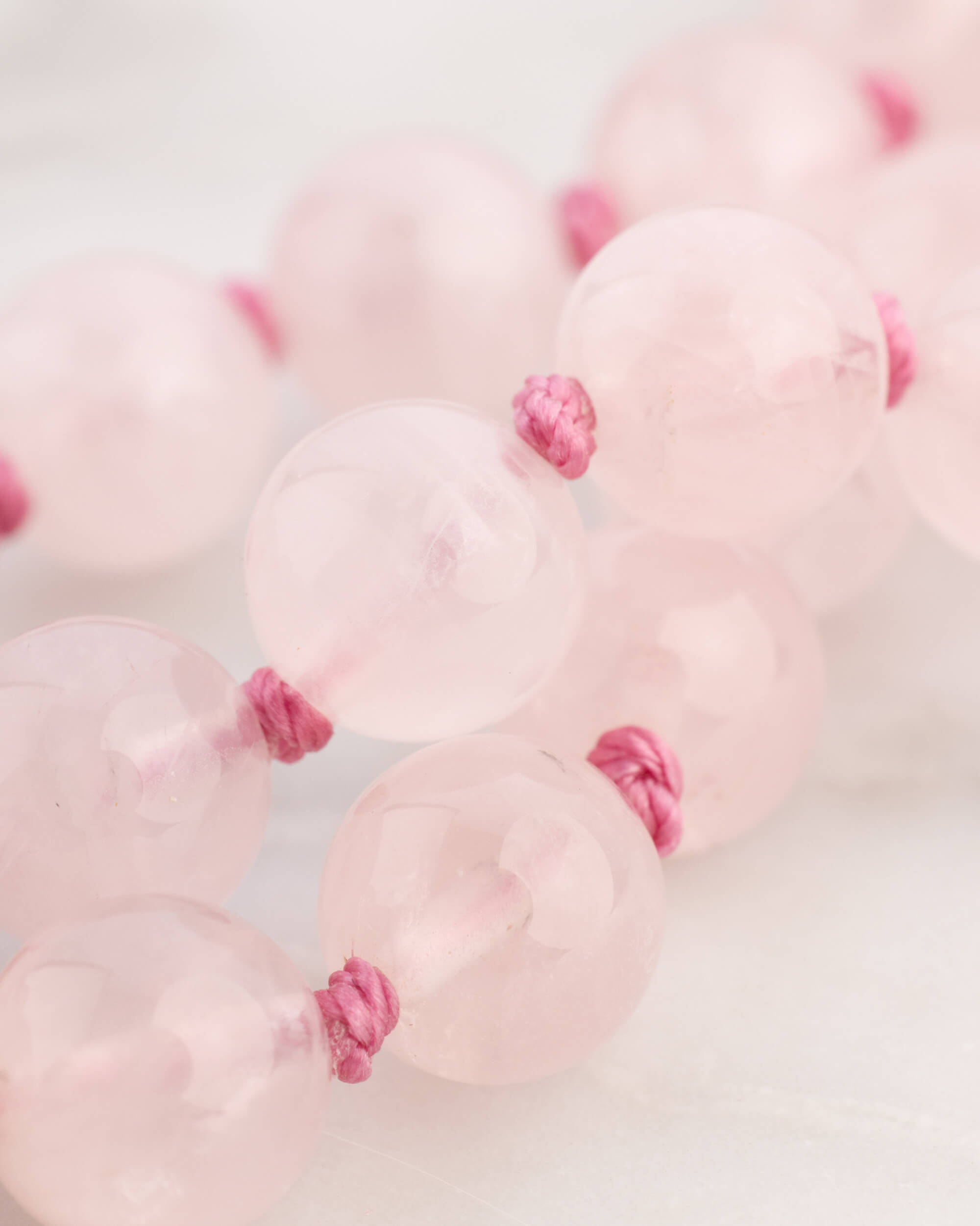 Detalle macro de las cuentas de Cuarzo Rosa con nudos entre cada una