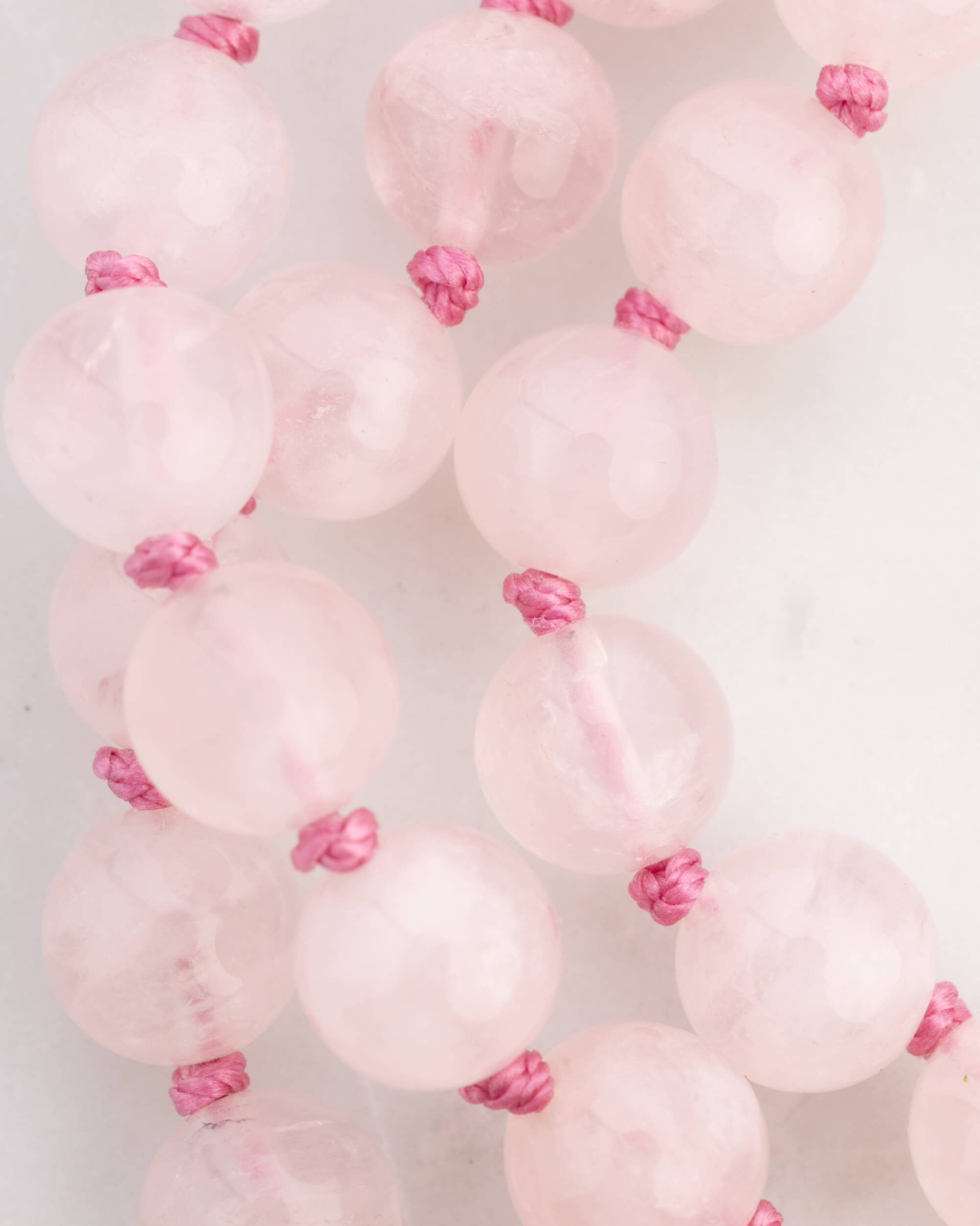 Detalle macro de las cuentas de Cuarzo Rosa con sus nudos rosados