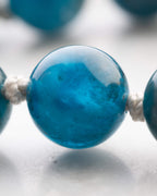 Japa Mala de Apatita Azul puesto, visto de cerca sobre la nuca