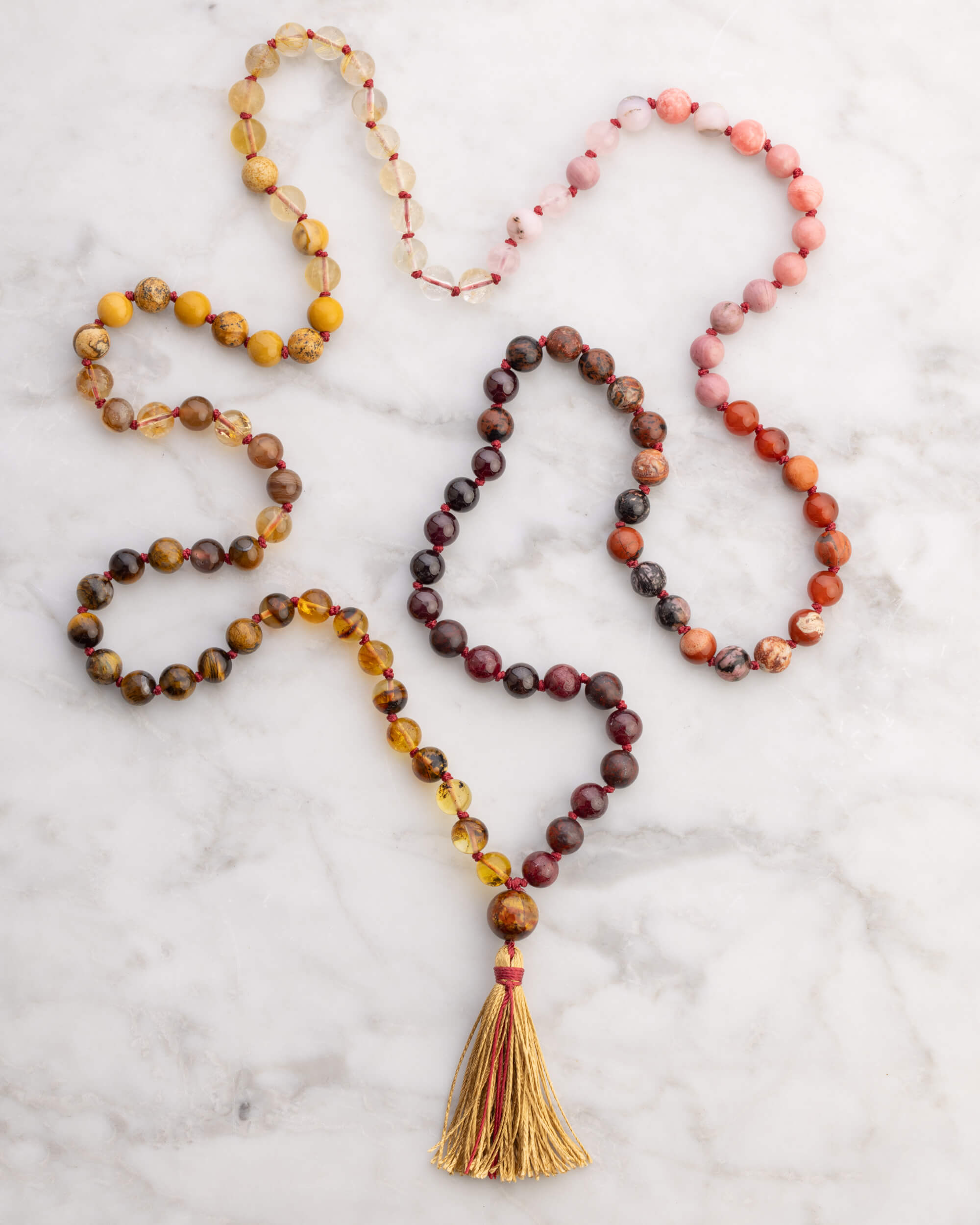Japa Mala Fuego de 8 mm, pieza completa en forma de corazon sobre mármol claro