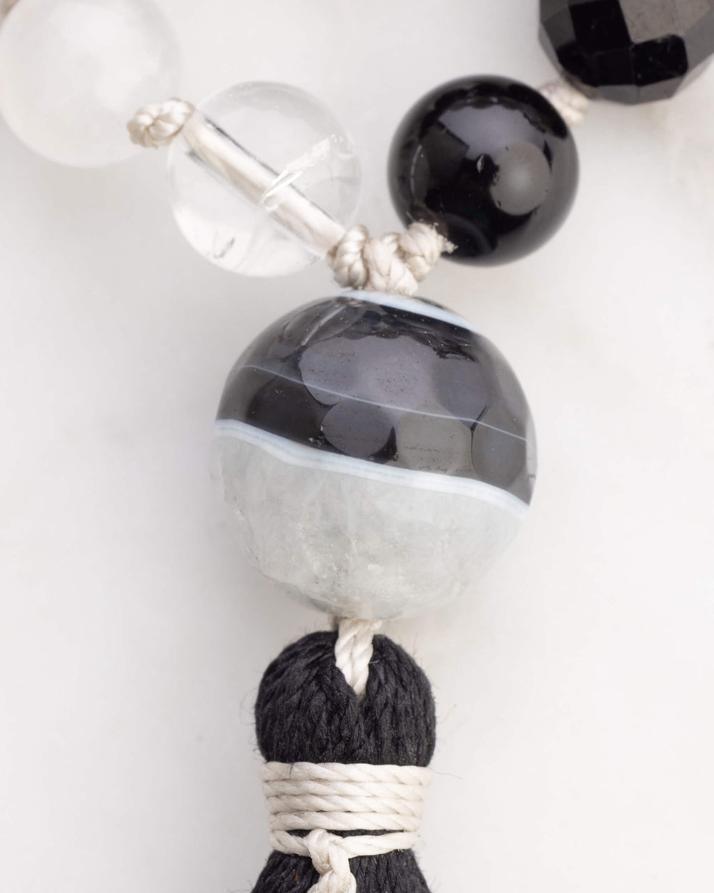 Detalle macro de la cuenta grande bicolor y la borla negra del Japa Mala Dualidad