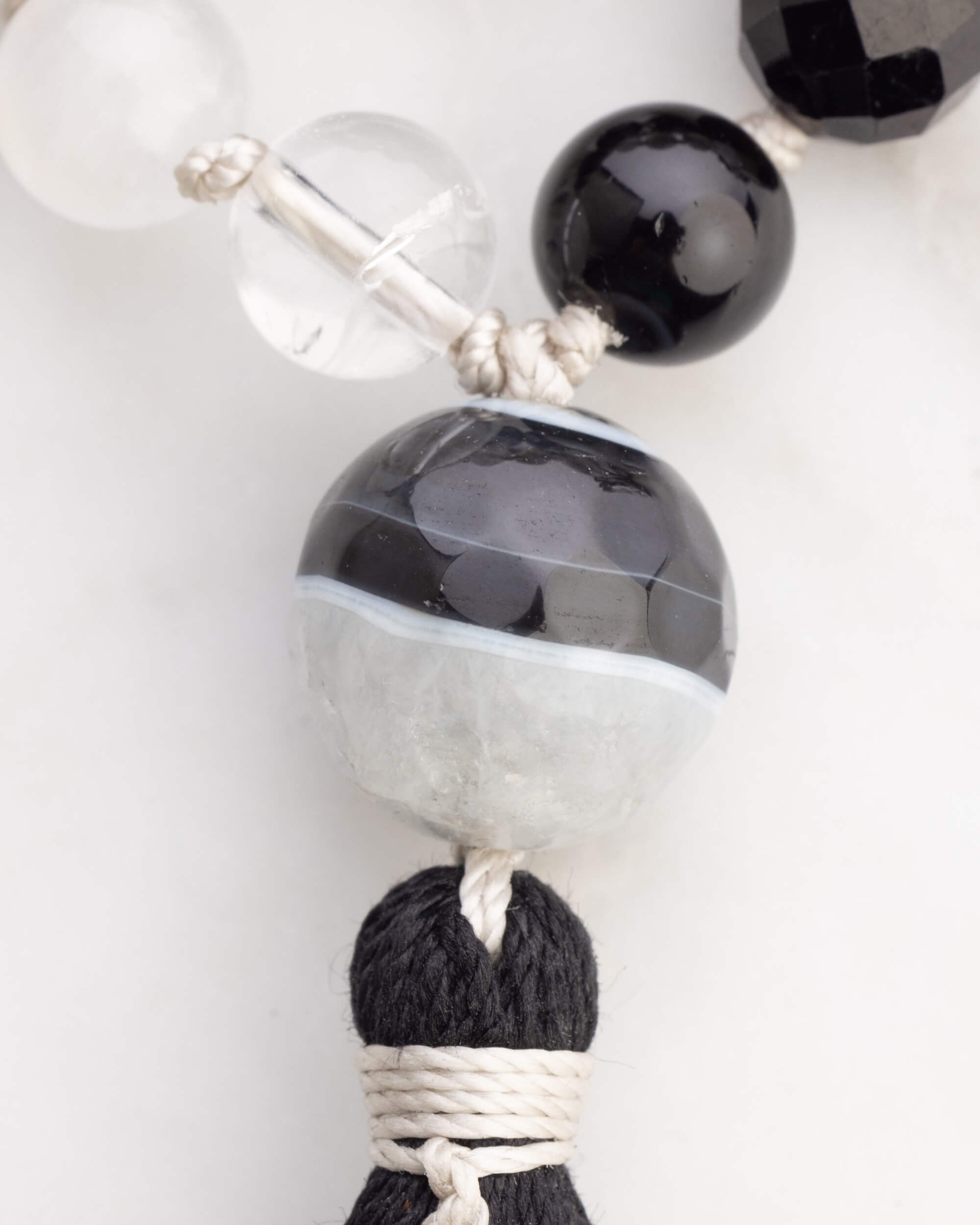Detalle macro de la cuenta grande bicolor y la borla negra del Japa Mala Dualidad